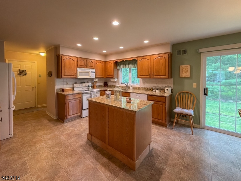 29 Lark Lane Oak Ridge, NJ 07438 - Photo 6 of 26 a kitchen with kitchen island a stove a sink a counter top space cabinets and a view of living room