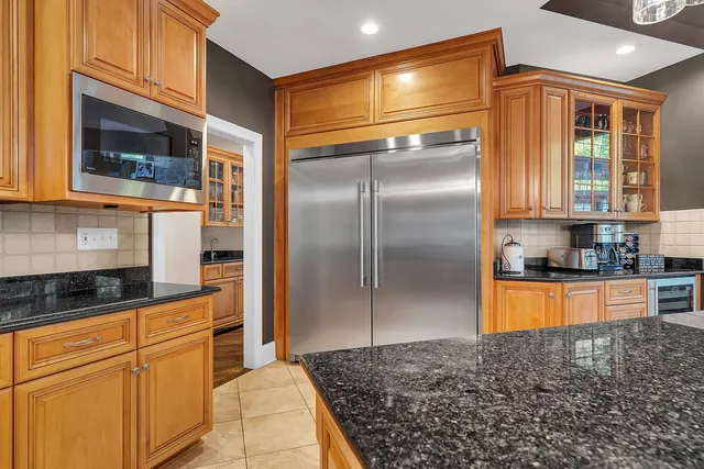 a kitchen with stainless steel appliances granite countertop a stove top oven a sink dishwasher and cabinets with wooden floor