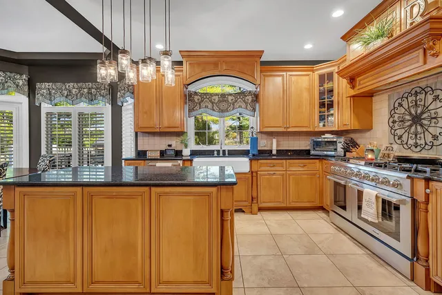 a kitchen with stainless steel appliances granite countertop a stove a sink and a microwave