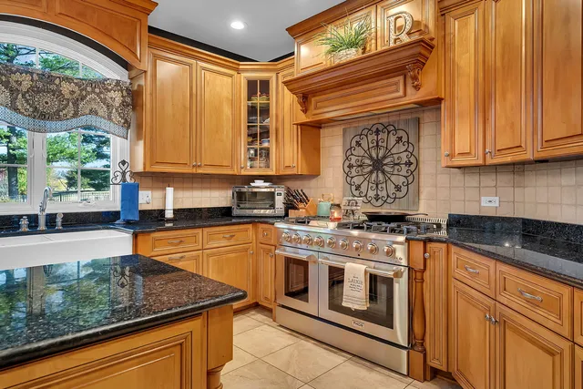 a kitchen with stainless steel appliances granite countertop a sink a stove and cabinets