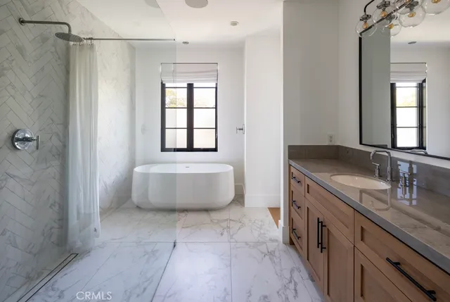 a spacious bathroom with a double vanity sink toilet mirror and bathtub