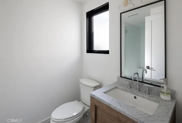 a bathroom with a sink toilet and mirror