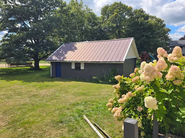 a view of a house with a yard and a tree