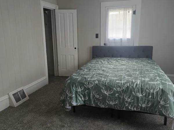 a bed sitting in a bedroom next to a window