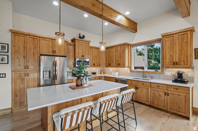 4892 Eagle Rdg Drive Eden, UT 84310 - Photo 10 of 39 Spacious kitchen featuring extensive wood cabinetry, a large center island with a white countertop, and stainless steel appliances