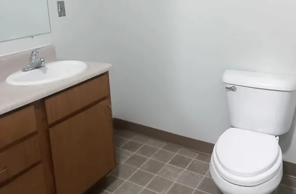 a white toilet sitting next to a bathroom sink