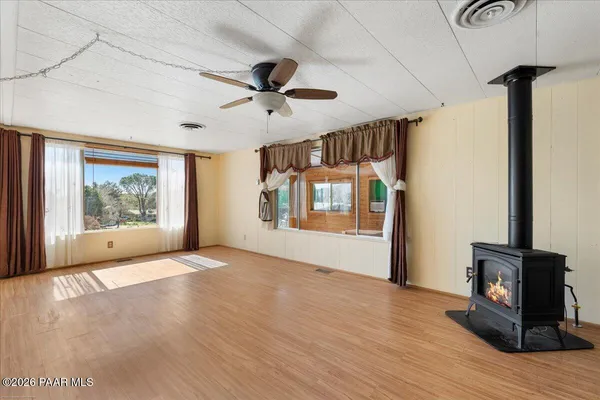 a view of empty room with wooden floor and fan