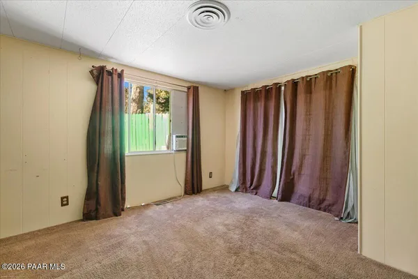 an empty room with a window and furniture