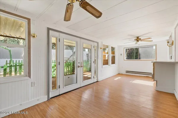 a view of an empty room with window and wooden floor