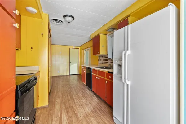 a kitchen with stainless steel appliances granite countertop a refrigerator a stove and a wooden floors