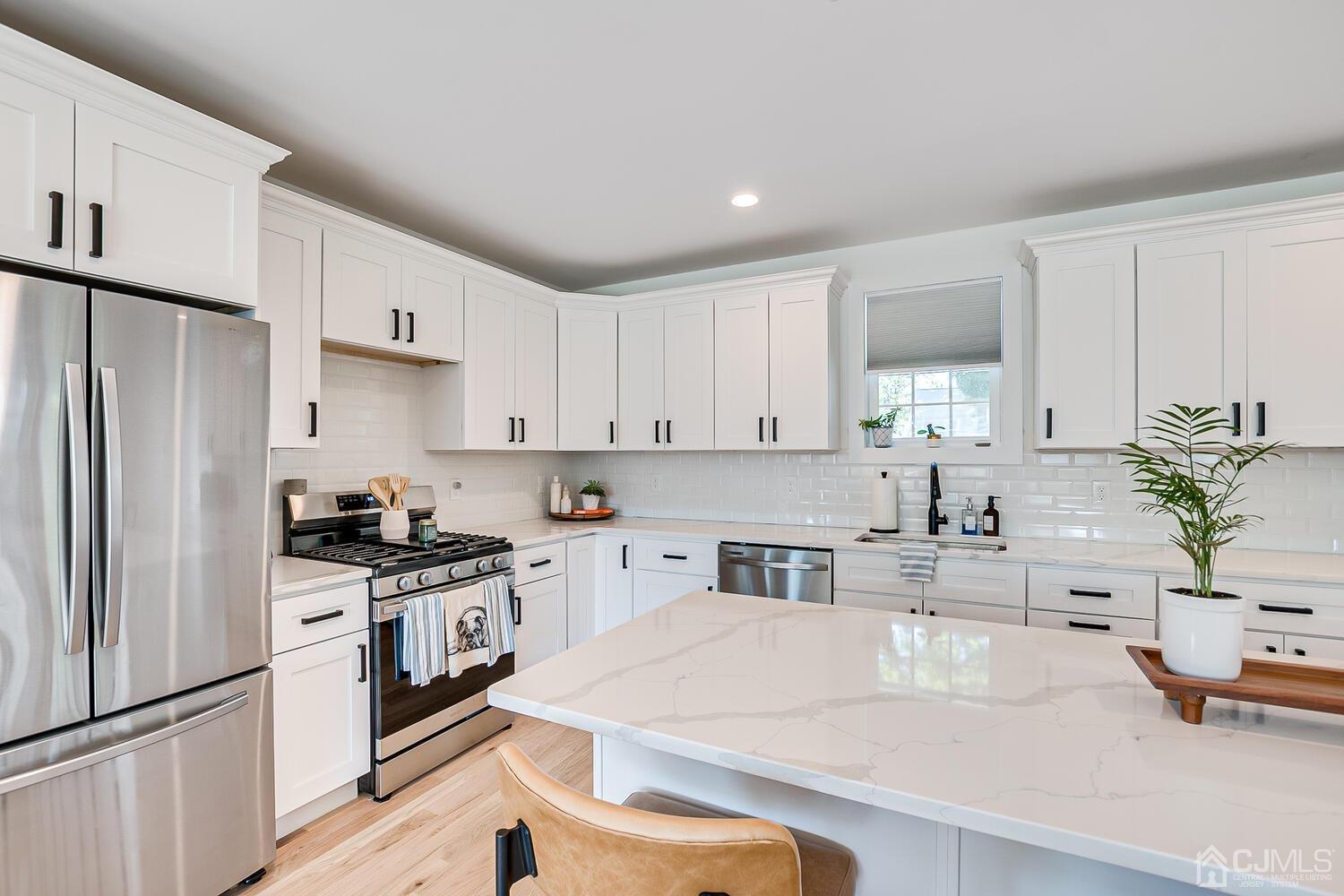 31 Carlton Street Edison, NJ 08837 - Photo 22 of 64 a kitchen with stainless steel appliances a sink a stove a refrigerator and cabinets