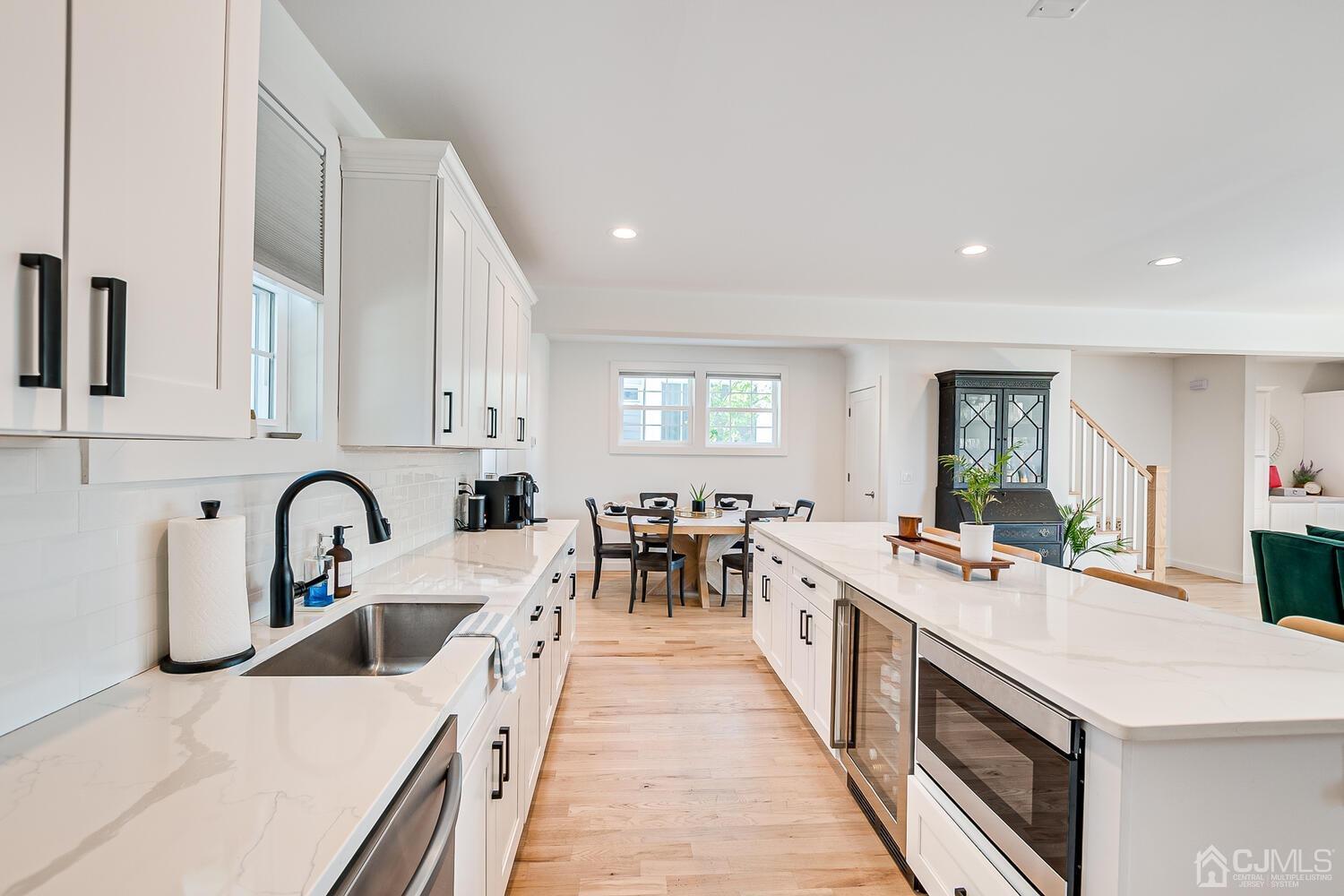 31 Carlton Street Edison, NJ 08837 - Photo 24 of 64 a large kitchen with stainless steel appliances a white stove top oven a sink a dining table and chairs