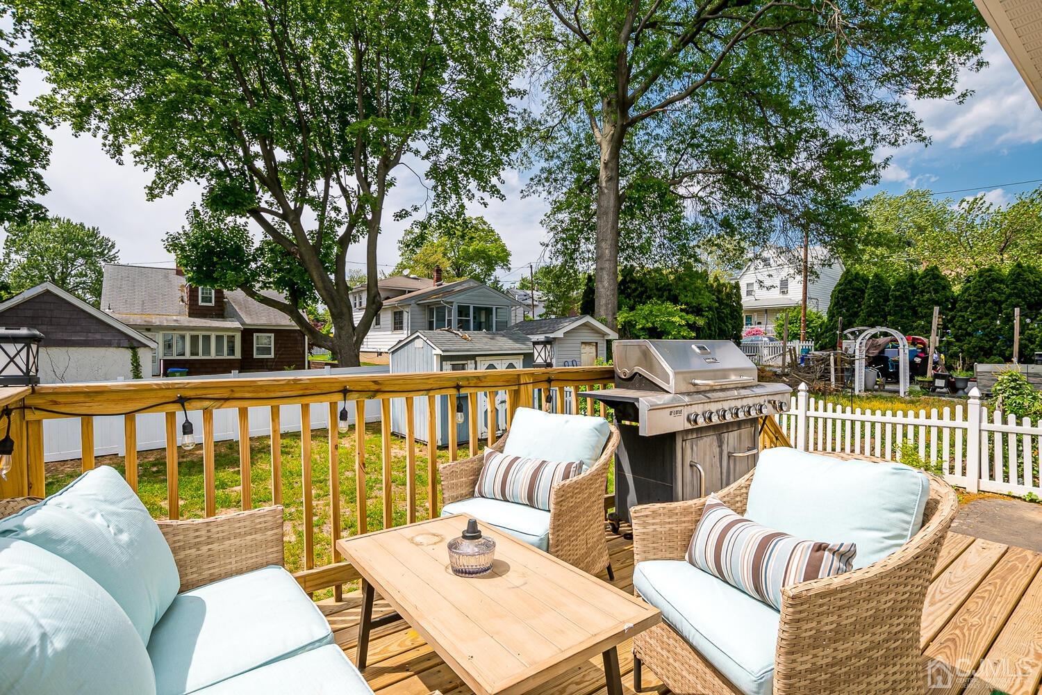 31 Carlton Street Edison, NJ 08837 - Photo 50 of 64 a view of a patio with couches dining table and chairs with wooden floor and fence