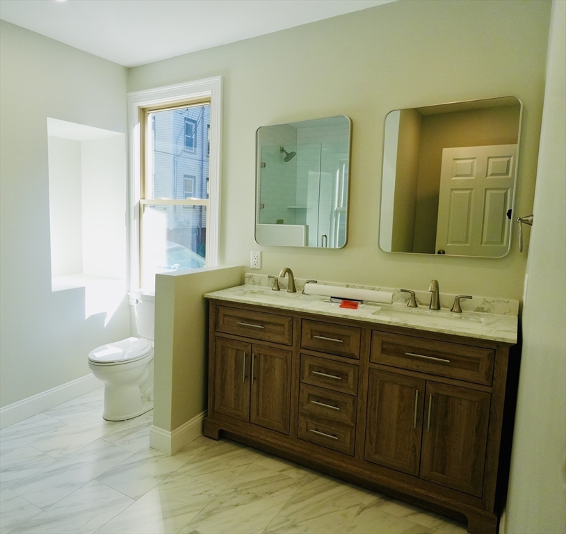 59 7th Street, Unit 1 Cambridge, MA 02141 - Photo 12 of 21 a bathroom with a double vanity sink and a mirror