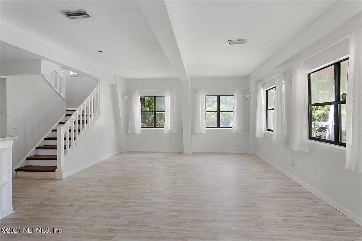 6263 Ricker Road Jacksonville, FL 32244 - Photo 5 of 26 a view of an empty room with wooden floor and windows