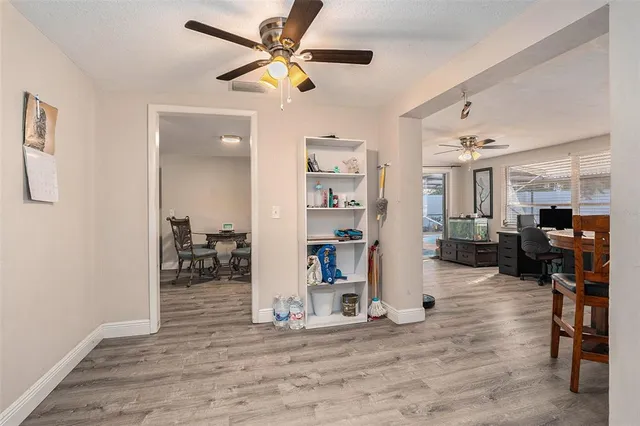 a view of a livingroom with wooden floor and a ceiling fan