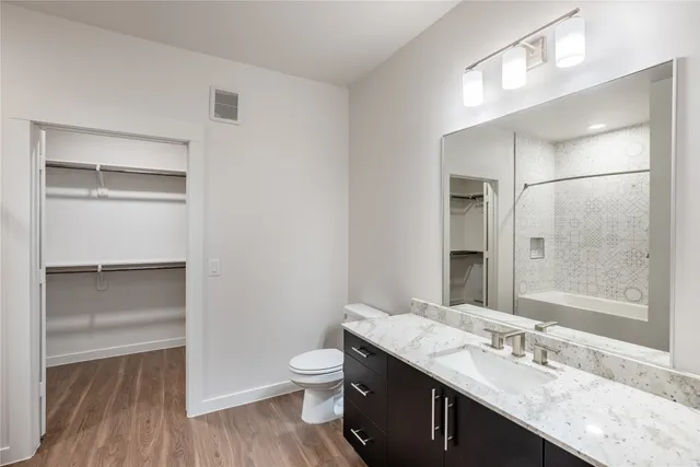 a bathroom with a granite countertop sink toilet and shower