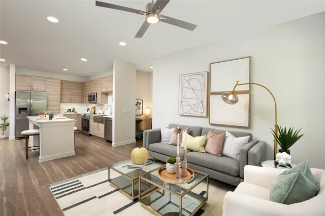 a living room with furniture kitchen view and a potted plant