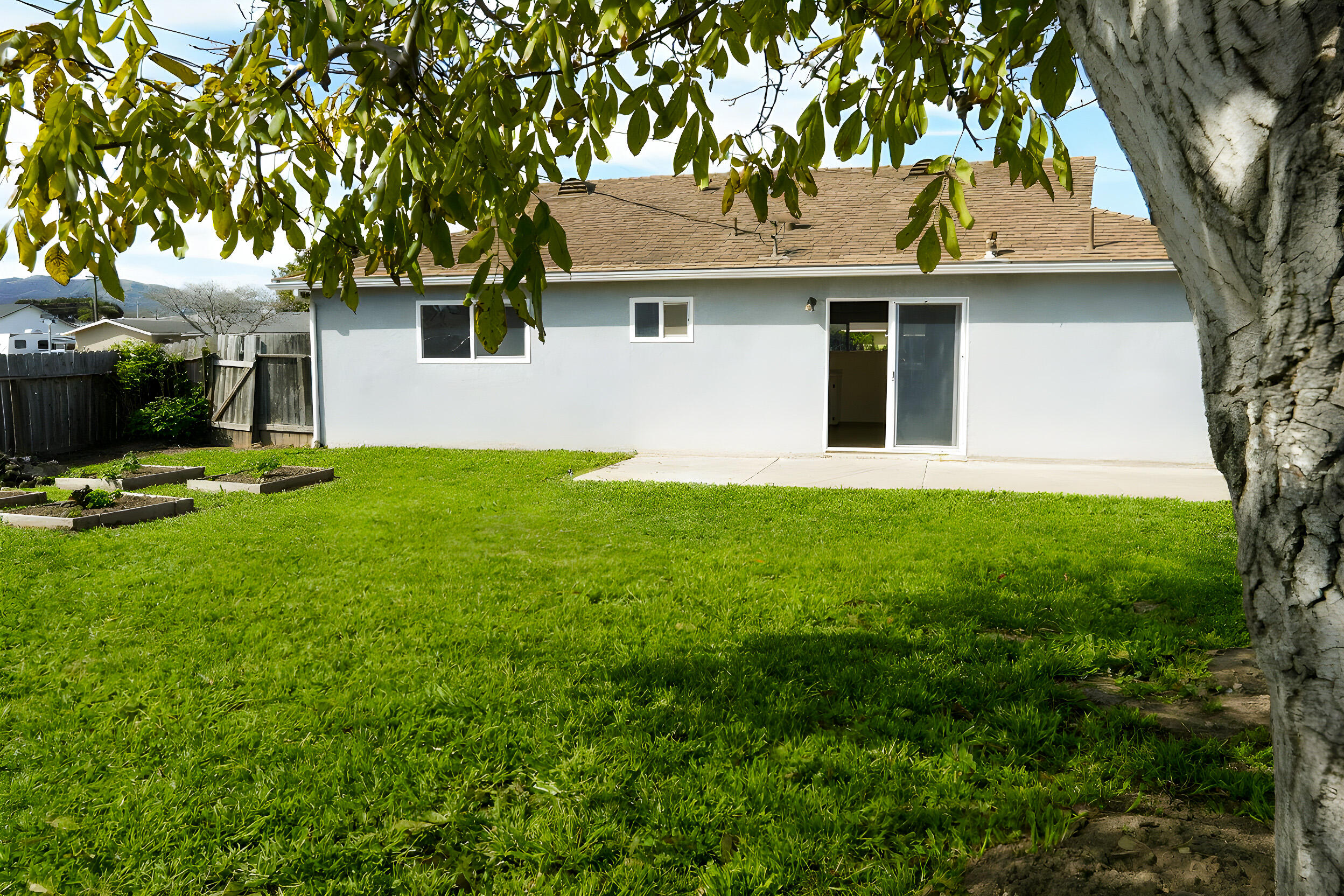 1100 North Third Street Lompoc, CA 93436 - Photo 12 of 12 a view of a white house with a yard and large trees