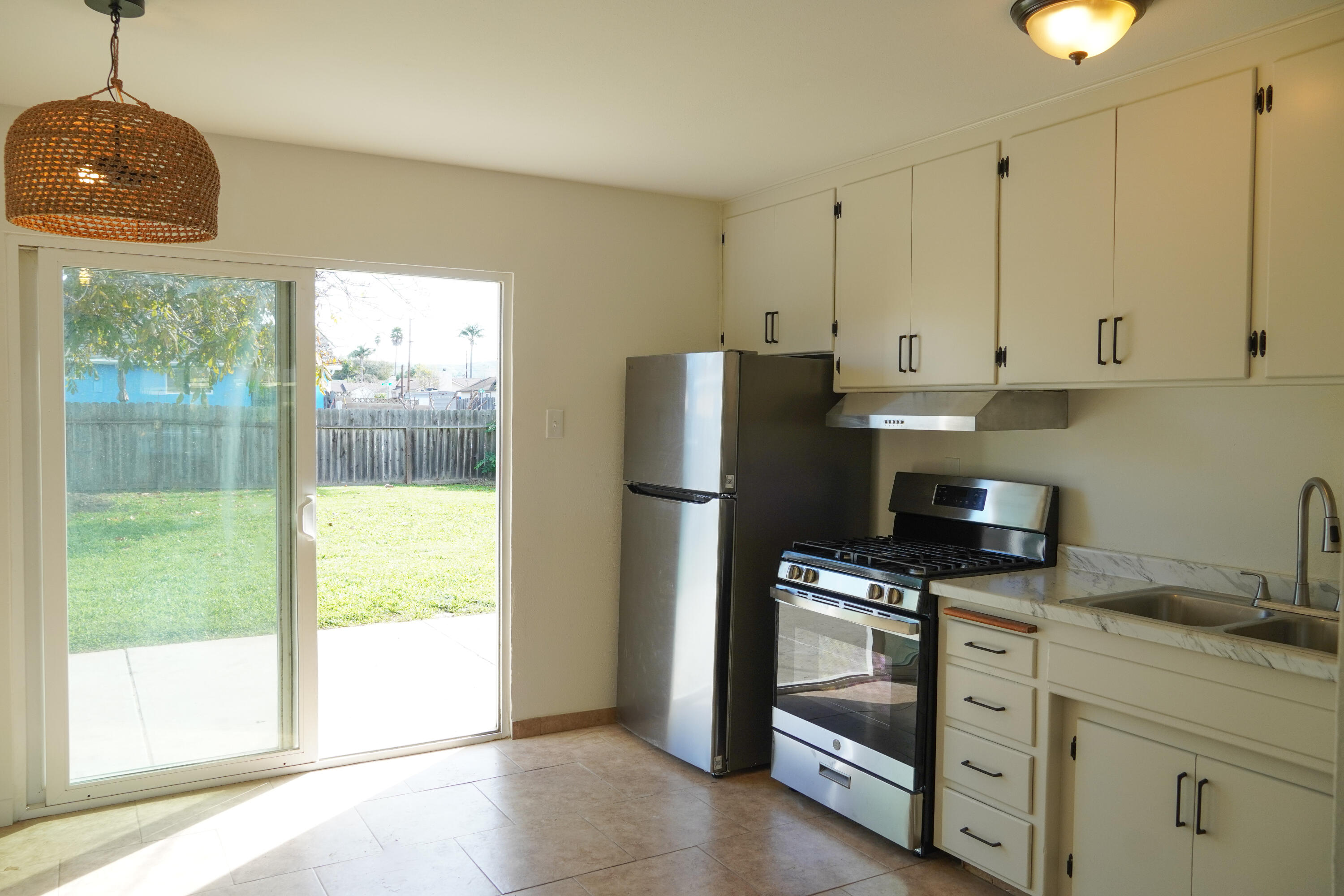 1100 North Third Street Lompoc, CA 93436 - Photo 7 of 12 a kitchen with stainless steel appliances granite countertop a refrigerator and a stove top oven