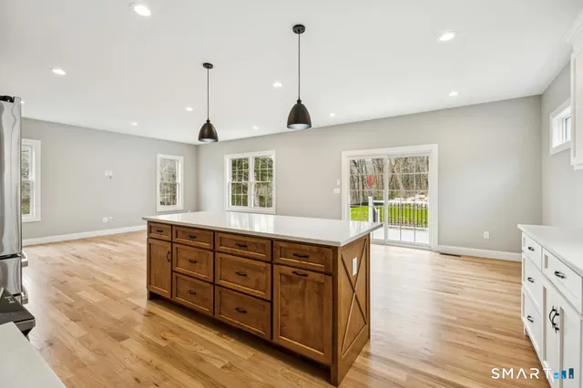 a spacious kitchen with stainless steel appliances granite countertop a sink and wooden floor