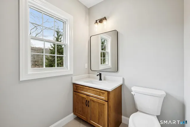 a bathroom with a toilet sink vanity and mirror