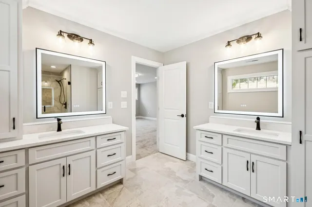 a bathroom with a sink vanity granite tub and a mirror
