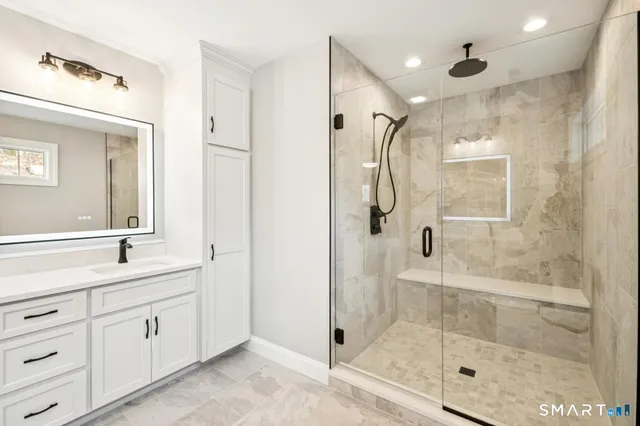 a spacious bathroom with a shower sink and mirror