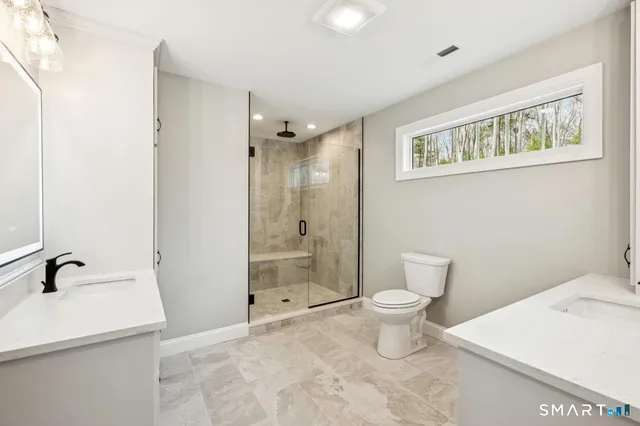 a bathroom with a sink a toilet and shower