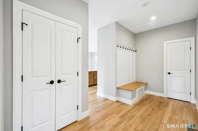 a view of a hallway with wooden floor and closet area