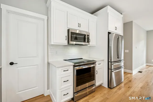 a kitchen with stainless steel appliances granite countertop a refrigerator stove and microwave