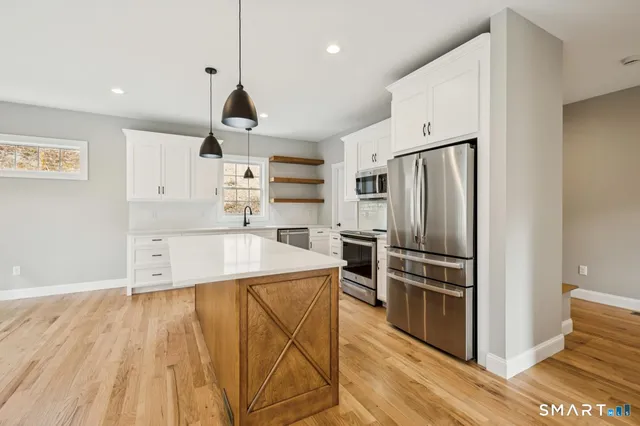 a large kitchen with cabinets wooden floor and stainless steel appliances