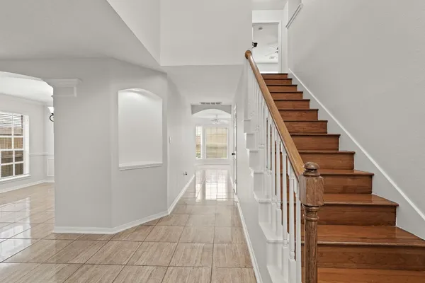 a view of a hallway with entryway and wooden floor