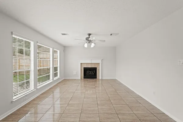 a view of a livingroom with a ceiling fan a fireplace and chandelier