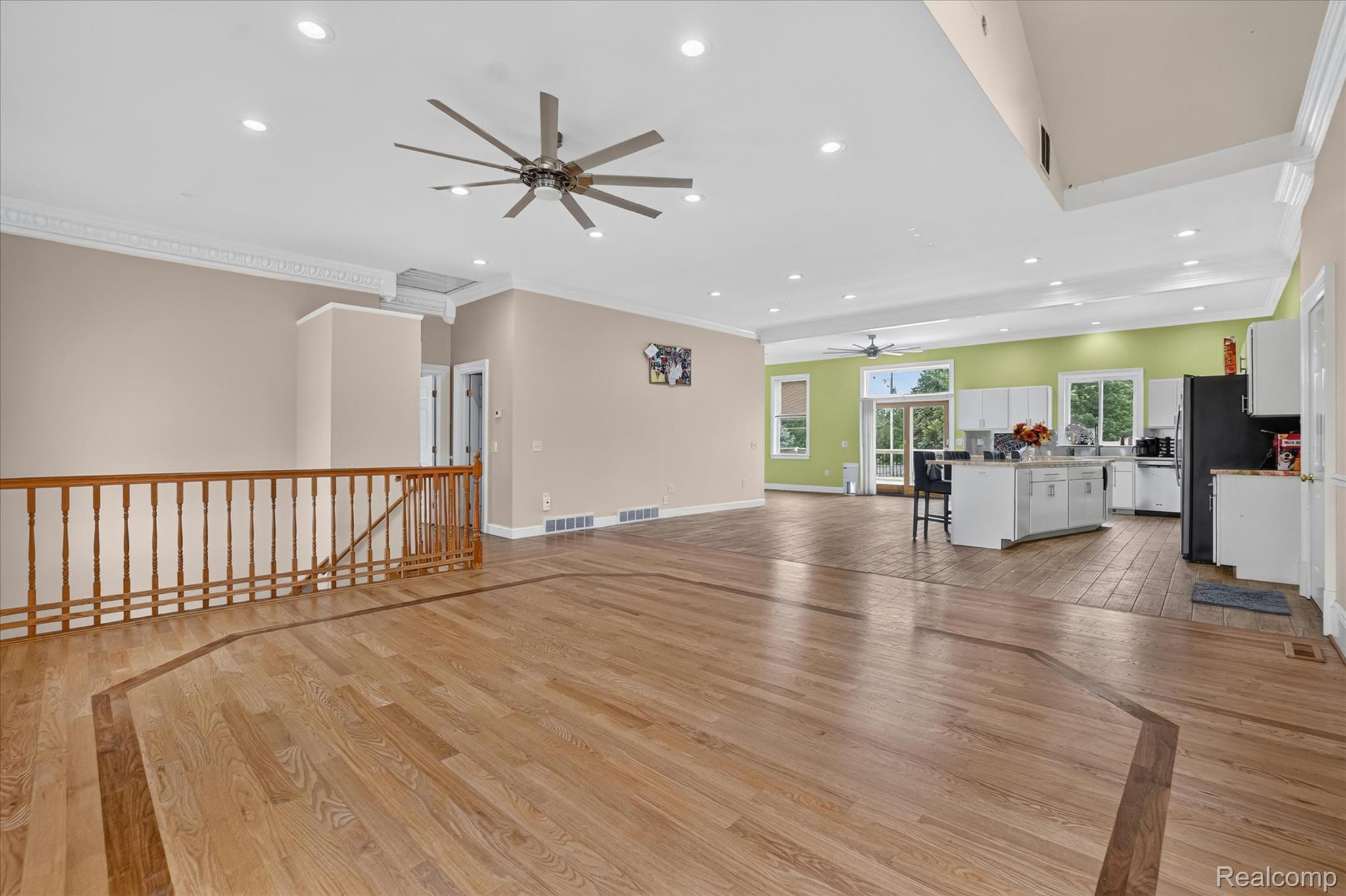 6524 Kelly Road Flushing, MI 48433 - Photo 9 of 47 Expansive open-concept living space featuring wood-finish flooring with decorative inlay, a ceiling fan, recessed lighting, and crown molding