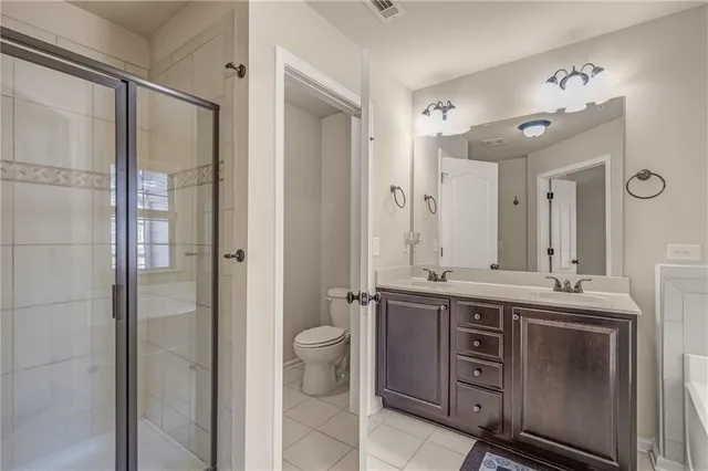 a bathroom with a tub a sink double vanity and a mirror