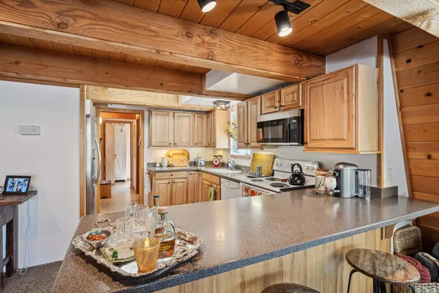 a kitchen with stainless steel appliances granite countertop a sink a stove and a wooden cabinets