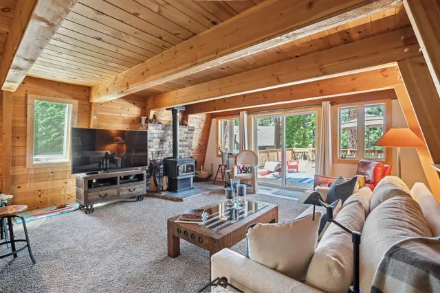 a living room with furniture a flat screen tv and a large window