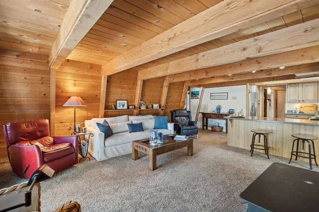 a living room with furniture a rug and white walls