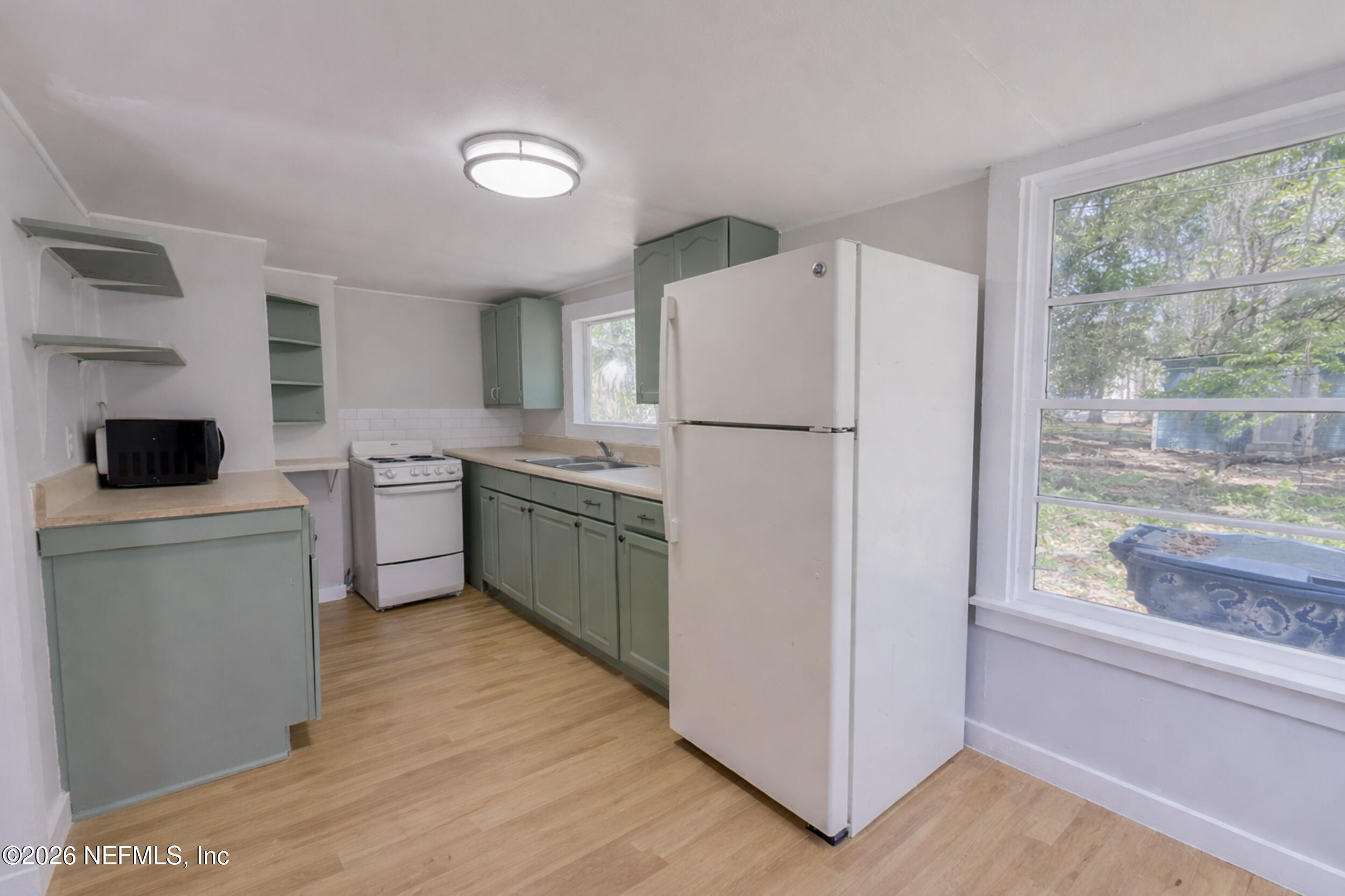 6300 Blanchard Road Jacksonville, FL 32216 - Photo 6 of 12 a kitchen with a refrigerator a sink and a stove top oven