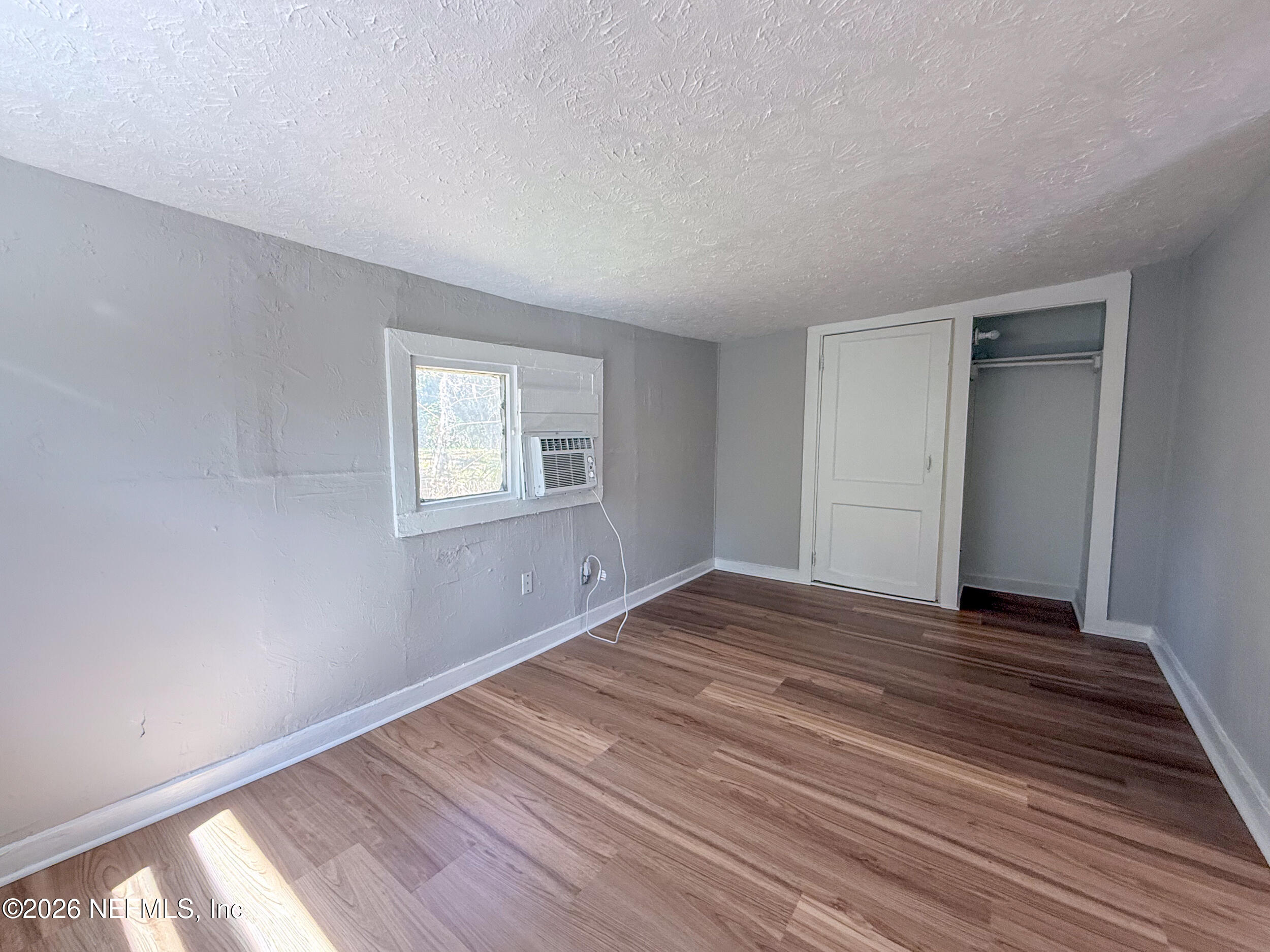 6300 Blanchard Road Jacksonville, FL 32216 - Photo 9 of 12 a view of an empty room with wooden floor and a window