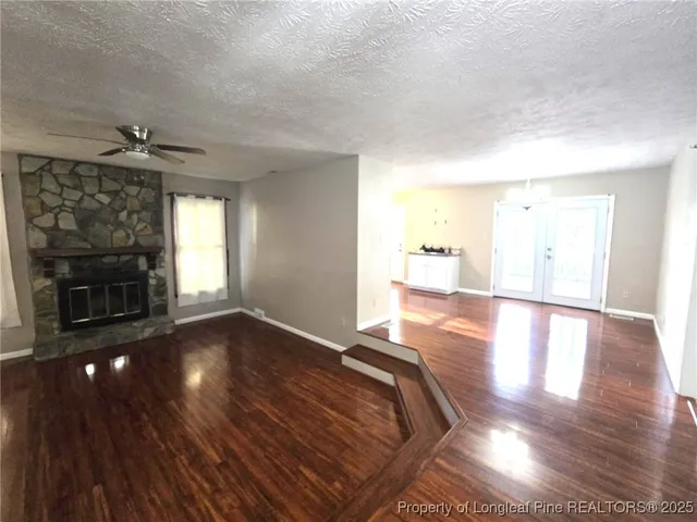 a view of empty room with wooden floor and fireplace