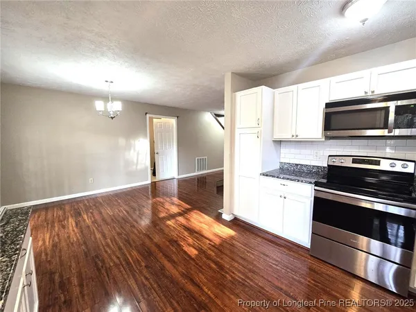 a kitchen with stainless steel appliances kitchen island granite countertop a stove a sink and a microwave