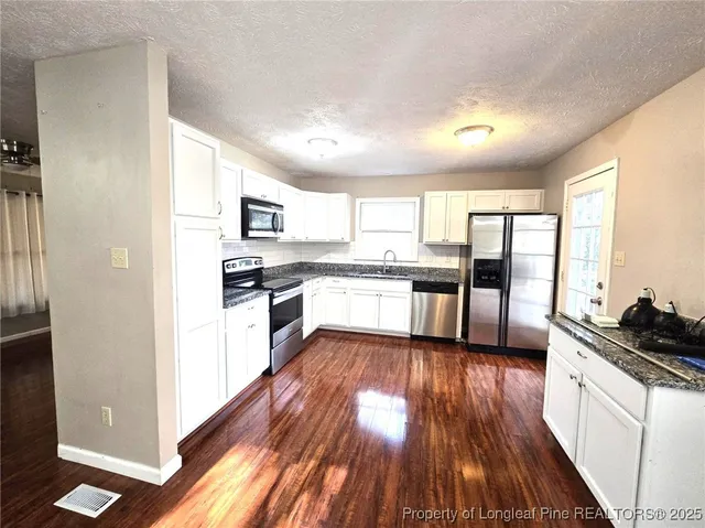a kitchen with wooden floors and appliances
