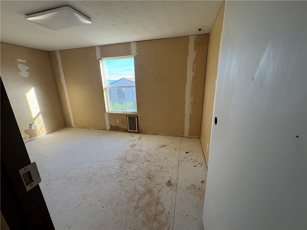 4938 Mormon Flat Road Golden Valley, AZ 86413 - Photo 10 of 23 Empty room with a textured ceiling