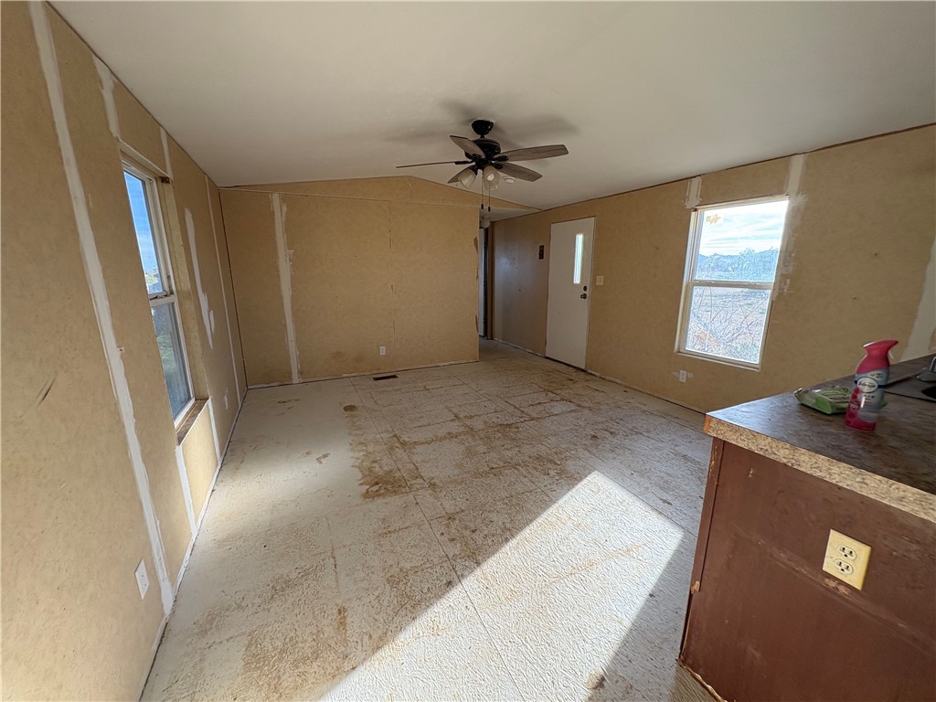 4938 Mormon Flat Road Golden Valley, AZ 86413 - Photo 3 of 23 Unfurnished living room with ceiling fan and lofted ceiling