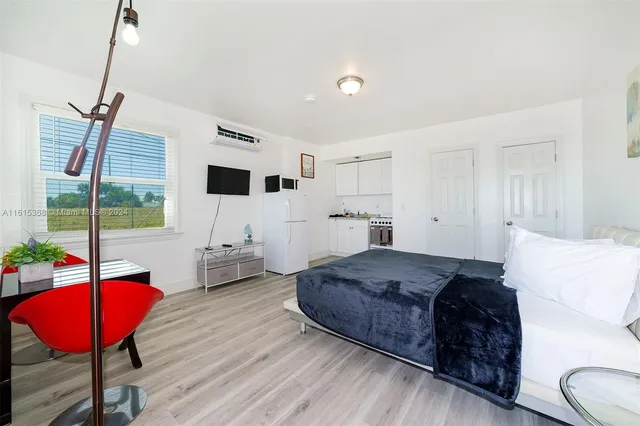 a spacious bedroom with a bed window and a flat screen tv