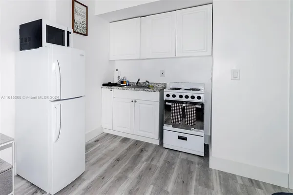 a kitchen with a refrigerator and a stove