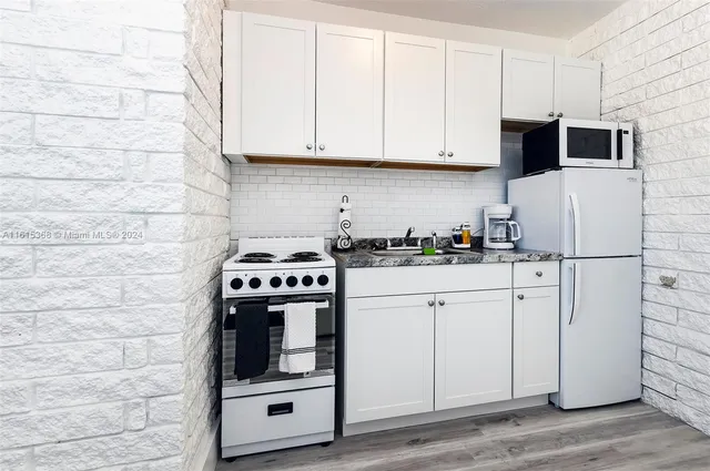 a white stove top oven sitting inside of a kitchen