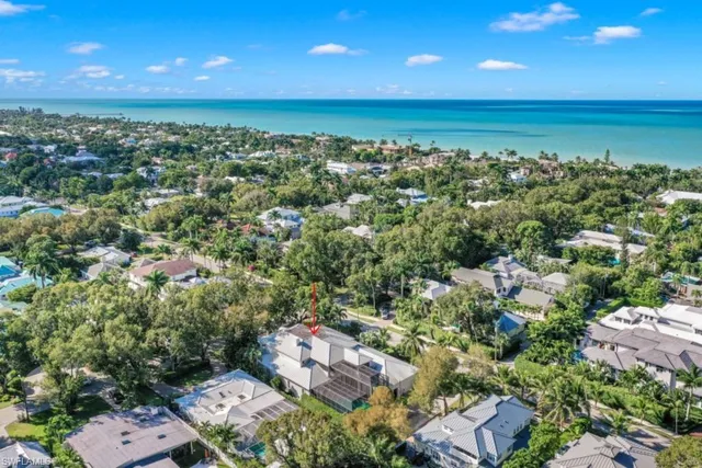 an aerial view of a city with lots of residential buildings and ocean view in back